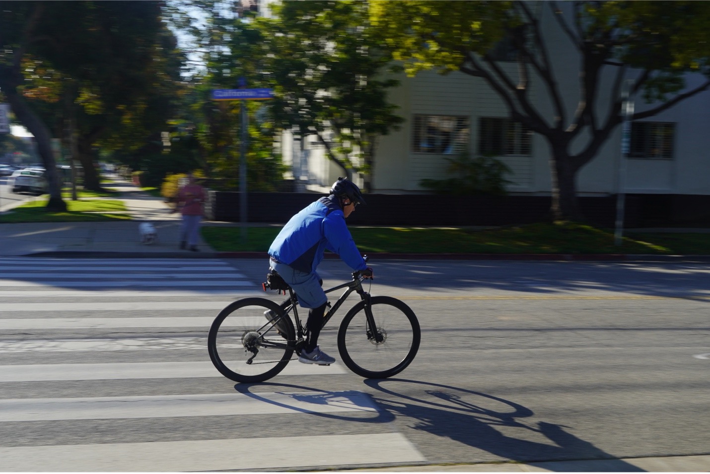 bike rider with blue jacket riding on the street